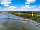 Aerial view of a waterfront property with a dock and boat lift, surrounded by green trees at 3060 Bohicket Rd, Johns Island, SC 29455