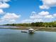 Stunning aerial shot of a dock featuring a gazebo extending over the water, set against a blue sky at 3060 Bohicket Rd, Johns Island, SC 29455
