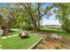 Tranquil backyard with stone patio, fire pit, mature trees, and scenic waterfront views at 3060 Bohicket Rd, Johns Island, SC 29455