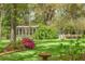 Backyard view with mature trees, potting shed, and lush greenery on a sunny day at 3060 Bohicket Rd, Johns Island, SC 29455