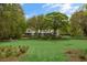 Expansive backyard featuring a meticulously manicured lawn and mature trees providing ample shade and privacy at 3060 Bohicket Rd, Johns Island, SC 29455
