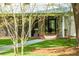 Covered porch with a hanging swing, outdoor seating, and a stone walkway leading to the house at 3060 Bohicket Rd, Johns Island, SC 29455