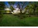 Exterior view of a charming home with lush landscaping and mature trees at dusk at 3060 Bohicket Rd, Johns Island, SC 29455
