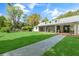 Spacious backyard with lush green lawn, screened-in porch, and stone walkway to the main house at 3060 Bohicket Rd, Johns Island, SC 29455