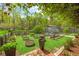 Manicured garden with a greenhouse and potting area on a sunny day at 3060 Bohicket Rd, Johns Island, SC 29455