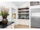 Kitchen area with open shelving, stainless refrigerator, and modern decor at 3060 Bohicket Rd, Johns Island, SC 29455
