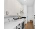 Modern laundry room with white cabinets, stainless steel appliances, and hardwood floors at 3060 Bohicket Rd, Johns Island, SC 29455