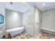 Updated main bathroom showcases a soaking tub, tiled walls and floors, and a walk-in shower at 3060 Bohicket Rd, Johns Island, SC 29455