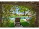 Relaxing poolside view with lounge chairs under a lovely pergola, framed by lush greenery and a glimpse of the water at 3060 Bohicket Rd, Johns Island, SC 29455