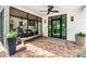 Covered porch with brick flooring, black framed windows, and a wooden bench at 3060 Bohicket Rd, Johns Island, SC 29455
