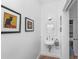 Stylish powder room featuring white walls, small sink and framed prints at 3060 Bohicket Rd, Johns Island, SC 29455
