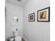 Bright powder room with toilet, framed art and small wall mirror at 3060 Bohicket Rd, Johns Island, SC 29455
