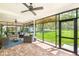 Screened porch featuring brick floors, ceiling fan, and comfortable seating area overlooking green lawn at 3060 Bohicket Rd, Johns Island, SC 29455