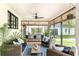 Inviting sunroom with comfortable wicker furniture, ceiling fan and view of lush backyard at 3060 Bohicket Rd, Johns Island, SC 29455