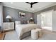 This primary bedroom features a gray accent wall, bedside tables with lamps, and a seating area to the ensuite bathroom at 316 Abercom Place Dr, Moncks Corner, SC 29461