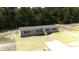 An aerial view of a single-story home with a well-maintained yard, beige siding, black shutters, and a paved pathway at 320 Bedford Rd, Cross, SC 29436