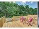 A charming back porch with a wooden deck, red furniture, and a view of lush greenery creates an outdoor retreat at 320 Bedford Rd, Cross, SC 29436