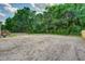 A large, empty lot with sandy soil is surrounded by lush greenery and mature trees, offering a spacious outdoor space at 320 Bedford Rd, Cross, SC 29436