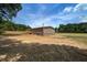 Single-story home with beige siding and wood deck, set on a spacious lot surrounded by lush greenery and a wooden fence at 320 Bedford Rd, Cross, SC 29436