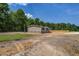 Beige single-story home with brick foundation and wooden deck on spacious lot ready for landscaping and lush surroundings at 320 Bedford Rd, Cross, SC 29436