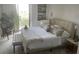 Comfortable bedroom features neutral tones, soft textiles, a decorative sitting bench, and access to a balcony, creating a calming retreat at 330 Concord St # 4B, Charleston, SC 29401