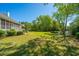 Spacious backyard featuring a screened porch, lush lawn, and a scenic pond in the distance at 3502 Stockton Dr, Mount Pleasant, SC 29466