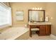 Bright bathroom features a soaking tub, a vanity with a stool, and a large window for lots of natural light at 3502 Stockton Dr, Mount Pleasant, SC 29466