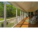 Inviting outdoor porch offers views of the green trees and two white rocking chairs at 3502 Stockton Dr, Mount Pleasant, SC 29466