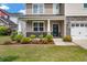 Inviting home exterior with a covered porch, manicured landscaping, and a two-car garage at 364 Deep River Rd, Summerville, SC 29486