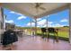 Relaxing screened-in patio with fan, barbecue, and view of the fenced backyard and pond at 364 Deep River Rd, Summerville, SC 29486