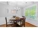 Elegant dining room featuring a modern chandelier, wainscoting, and a view of the porch at 408 Branch Creek Trl, Summerville, SC 29483