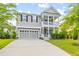 Charming home with a front porch, two-car garage, and a well-maintained lawn under a partly cloudy sky at 408 Branch Creek Trl, Summerville, SC 29483