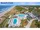 An expansive view of the beach club with multiple pools, umbrellas, chairs, and lovely landscape at 410 Ocean Oaks Ct, Kiawah Island, SC 29455