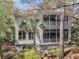 Charming exterior of a home with inviting screened porches surrounded by lush greenery at 410 Ocean Oaks Ct, Kiawah Island, SC 29455