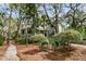 Beautifully landscaped exterior of a home with mature trees and inviting walkway at 410 Ocean Oaks Ct, Kiawah Island, SC 29455