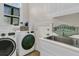 Functional laundry room complete with sink, storage, modern washer, and dryer at 410 Ocean Oaks Ct, Kiawah Island, SC 29455