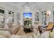 Bright living room featuring a fireplace, a ceiling fan, and comfortable seating arrangements at 410 Ocean Oaks Ct, Kiawah Island, SC 29455