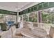 Spacious screened porch offering wooded views, ceiling fan, and outdoor dining area at 410 Ocean Oaks Ct, Kiawah Island, SC 29455