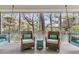 Relaxing porch with comfortable wicker chairs, side table, and a view of lush greenery at 410 Ocean Oaks Ct, Kiawah Island, SC 29455