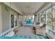 Inviting screened porch featuring swing beds, wicker chairs, and serene views of the surrounding landscape at 410 Ocean Oaks Ct, Kiawah Island, SC 29455