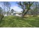 Expansive backyard with lush green grass, mature trees, and a privacy fence at 4209 Royal Harbor Rd, Hollywood, SC 29449