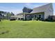 Spacious backyard with a covered patio, lush green lawn, and mature trees providing privacy at 4310 Cotton Flat Rd, Summerville, SC 29485