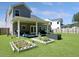 Well-maintained backyard featuring raised garden beds, a covered patio, and ample green space, great for relaxation and gardening at 4310 Cotton Flat Rd, Summerville, SC 29485