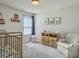 Bright Bedroom with vintage crib, wooden dresser, chair and artwork at 4310 Cotton Flat Rd, Summerville, SC 29485