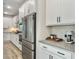Bright kitchen showcasing stainless steel refrigerator, white cabinets and hardware, and light wood-look flooring at 4310 Cotton Flat Rd, Summerville, SC 29485
