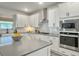 Spacious kitchen featuring an island, stainless steel appliances, and lots of white cabinets and grey countertops at 4310 Cotton Flat Rd, Summerville, SC 29485