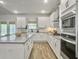 Bright kitchen featuring white cabinets, stainless steel appliances, and a kitchen island with gray countertops at 4310 Cotton Flat Rd, Summerville, SC 29485