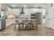 Bright kitchen with white cabinets, stainless steel appliances, an island with bar stool seating, and wood grain floors at 4310 Cotton Flat Rd, Summerville, SC 29485