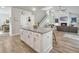 Open-concept view from the kitchen showing the island with seating, hardwood floors, fireplace, and staircase at 4310 Cotton Flat Rd, Summerville, SC 29485