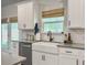 Bright kitchen with white cabinets, gray countertops, and a farmhouse style sink with black fixtures at 4310 Cotton Flat Rd, Summerville, SC 29485
